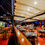 Thumbnail: Restaurant interior with tables, people, and bar; wooden floor and ceiling lights.