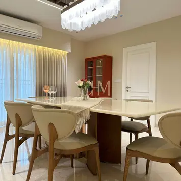 Contemporary dining area by hohm editors, interior designers in Hyderabad, featuring a sleek round dining table with six modern chairs, geometric false ceiling with recessed lighting, glass-fronted cabinet, floor-to-ceiling curtains, and a seamless open layout blending into the living space—ideal for sophisticated urban homes.