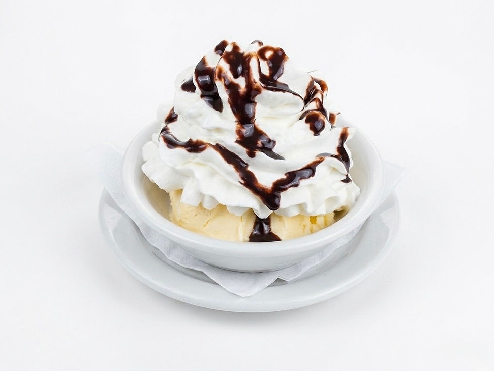 Vanilla ice cream topped with whipped cream and chocolate syrup.