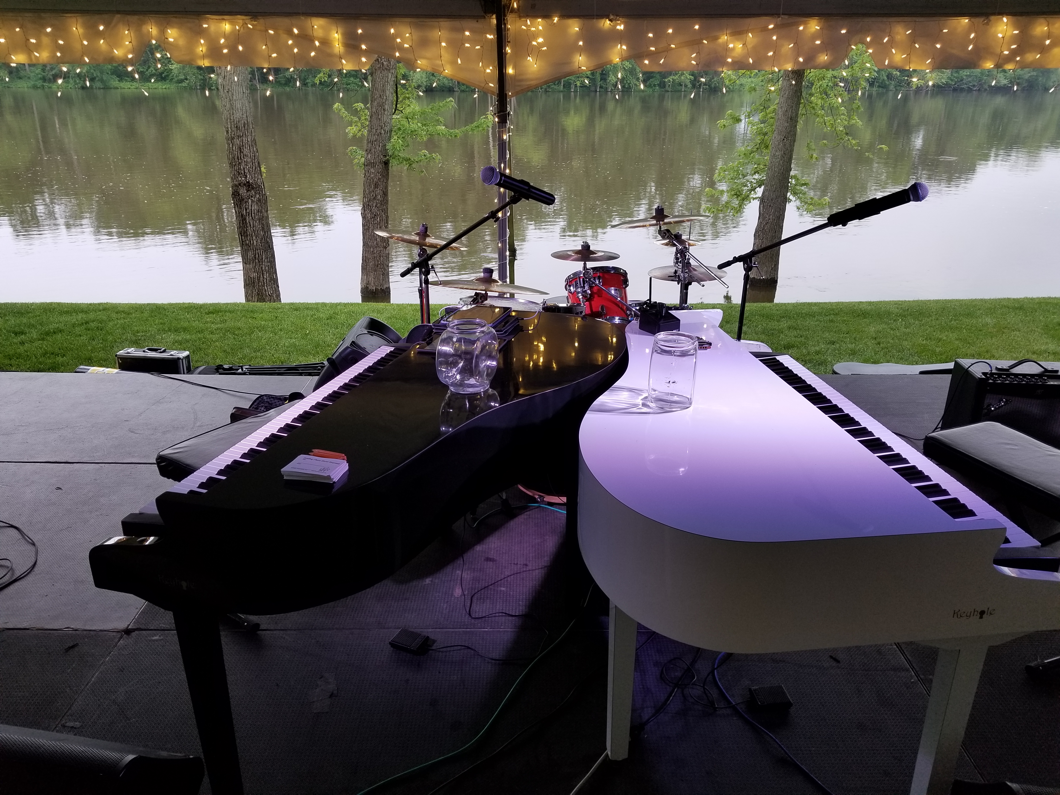 A white Keyhole grand shell under an outdoor event tent