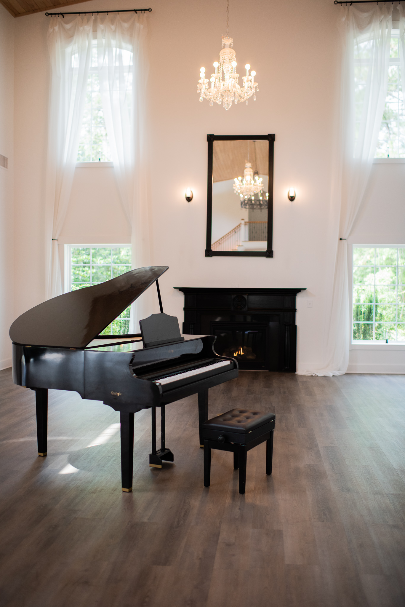 A black Keyhole grand piano shell in a bright living room