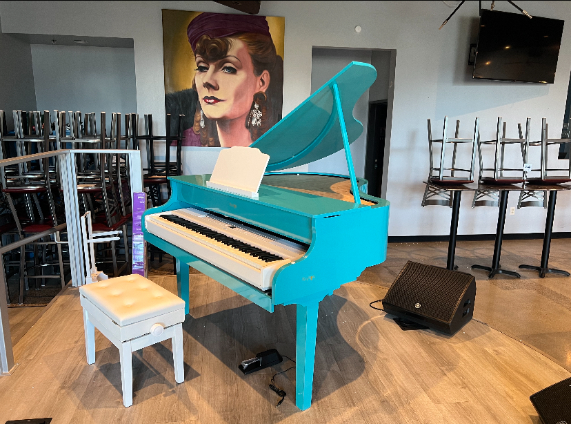 A teal Keyhole TurnKey grand shell in a music room
