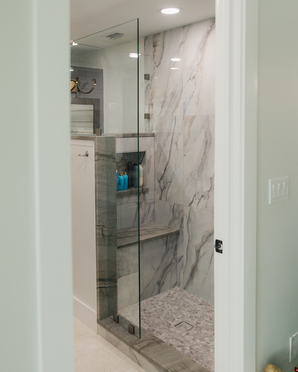 Luxury bathroom shower design with marble wall tiles and glass door