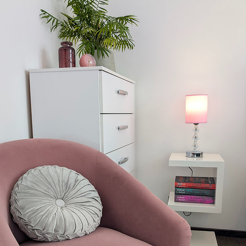 Modern interior design with pink armchair and white furniture.