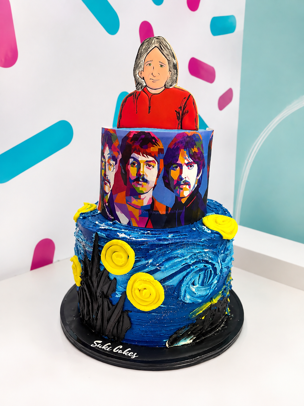 Pastel personalizado de Suki Cakes con galleta retrato y decoración temática en tonos azul y rojo.