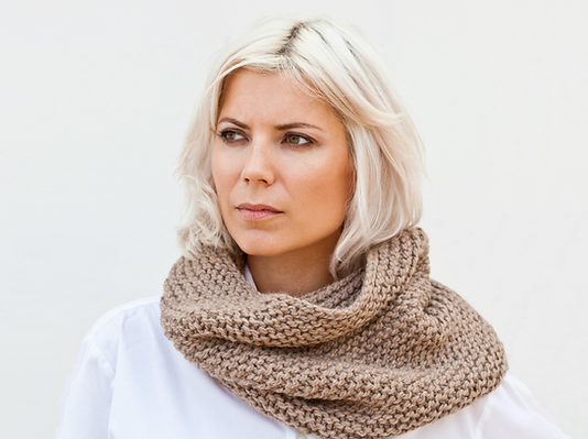 A woman with blonde hair wearing a scarf