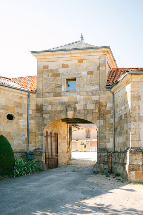 entrée du domaine des vieux métiers à azannes en Meuse. Les murs sont anciens et en pierre, le portail est ouvert