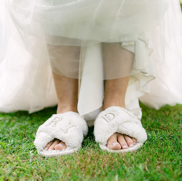 Pantoufle de mariée dans l'herbe le jour de son mariage dans sa robe de mariée en Meuse