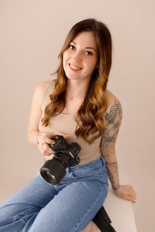 Femme Photographe de mariage en Meuse et en Wallonie qui tient un appareil photo. Nina Photographie fait des photos fine art lumineuse douces et romantiques