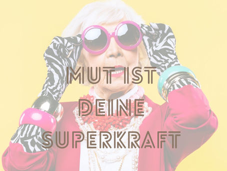 Ältere Frau mit pinker Sonnenbrille, auffälligem Schmuck und Handschuhen vor gelbem Hintergrund mit der Aufschrift „Mut ist deine Superkraft“