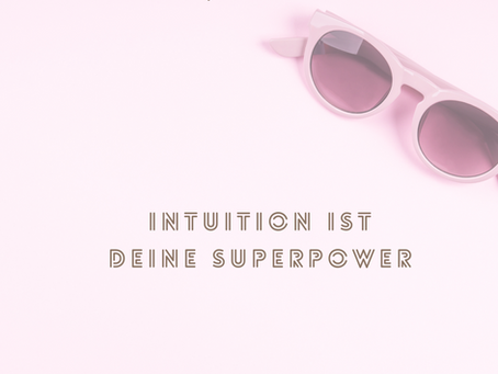 Rosa Sonnenbrille auf hellem rosa Hintergrund mit der Aufschrift „Intuition ist deine Superpower“