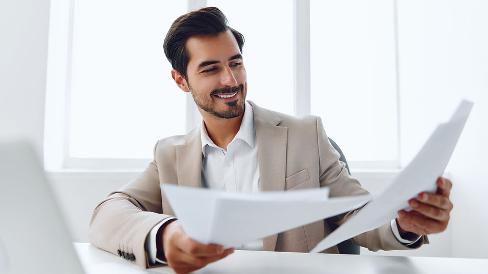 man in office looking at papers and smiling