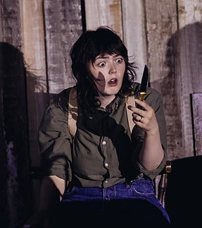 Kirsty Pickering, as Macbeth, is surprised to be holding a knife.