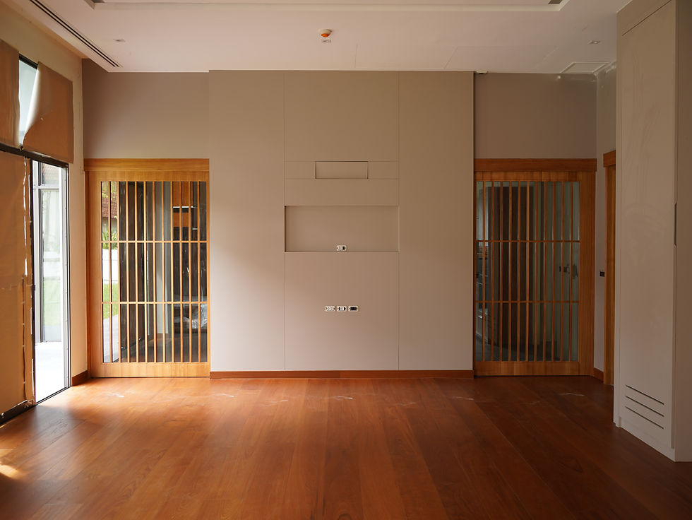 A bright, modern minimalist interior featuring custom Japandi-style wooden slatted sliding doors and premium wood flooring, engineered and fabricated by THAVII Furniture & Craft.