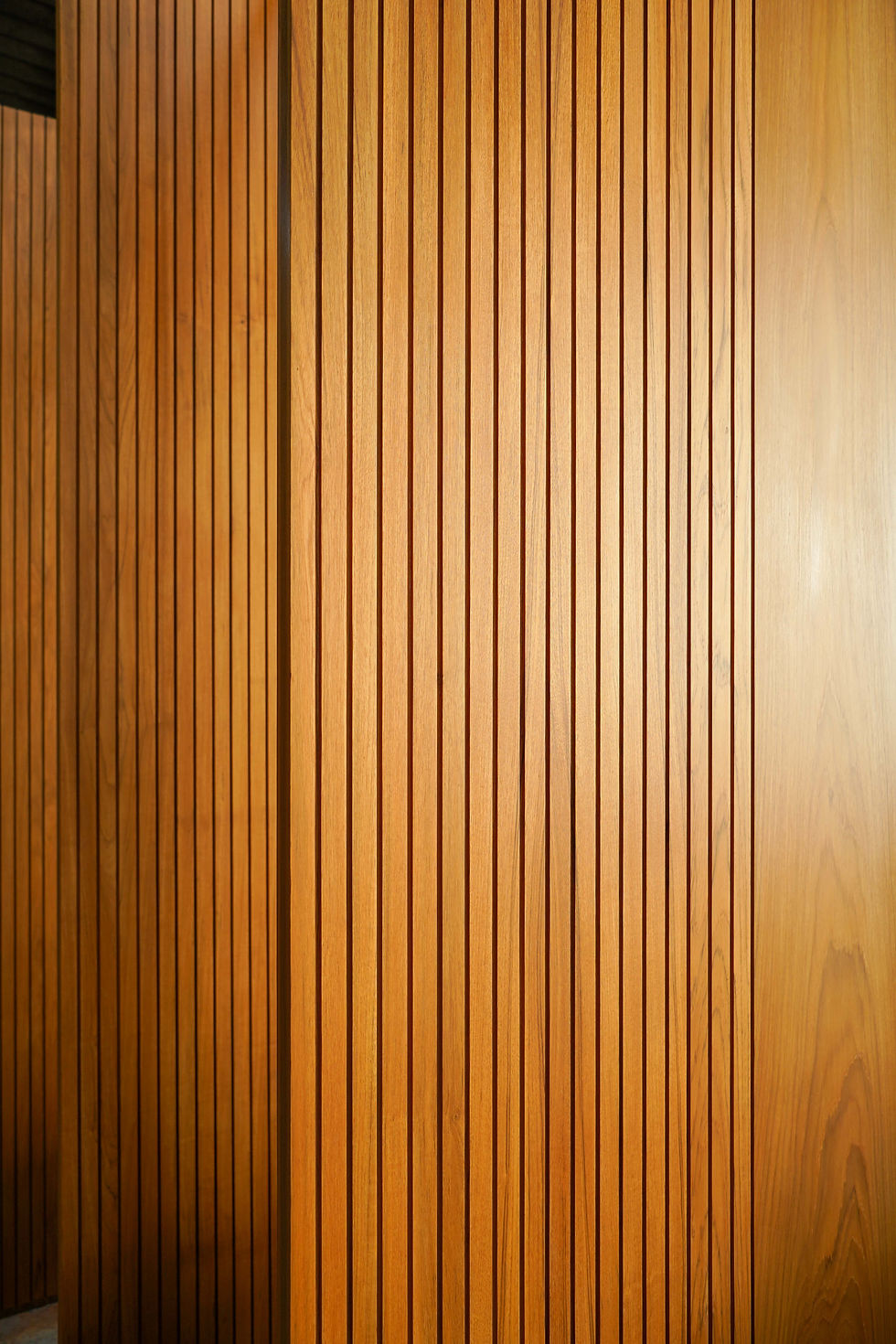 Teak door with groove design, Japandi, minimalistic. The light cast a soft lighting showing a beautiful wood grain, picked by expert from THAVII Furniture and Craft, Thailand