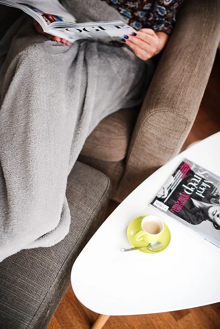 A Woman Reading Magazines and Having a Cup of Coffee