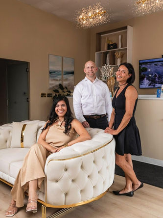 Three people pose in a spa setting in a massage specials setting.