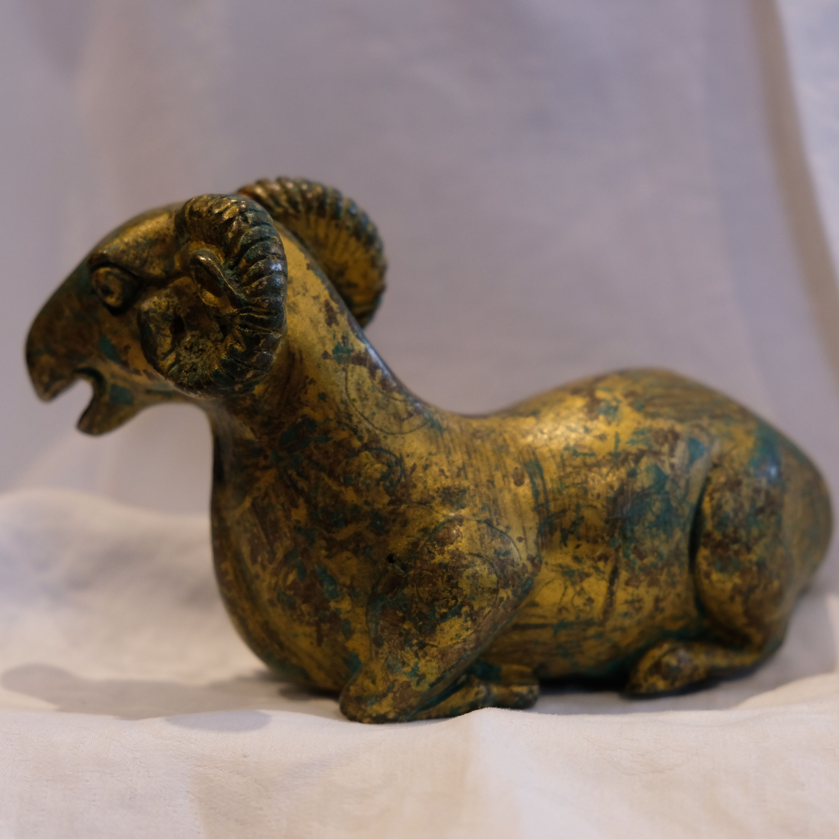 A Chinese gilded bronze in the form of a ram, 9 x 14cm