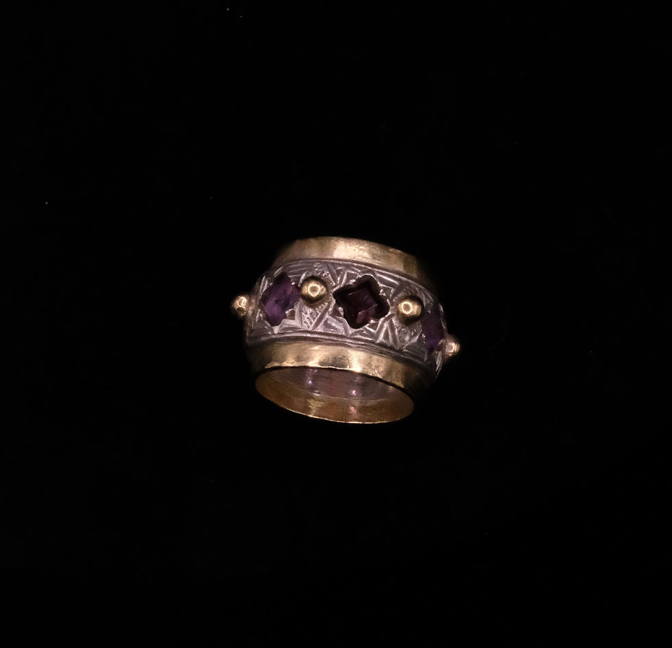 A silver and gold Michael Bolton ring set with amethysts and garnet, hallmarked