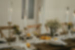 Tisch mit mediterraner Deko aus Zitronen, Olivenzweigen und weißen Blumen und Kerzen