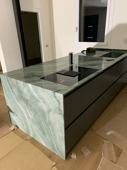 Isola cucina con piano in marmo verde, elettrodomestici, design moderno, Eb Traslochi.