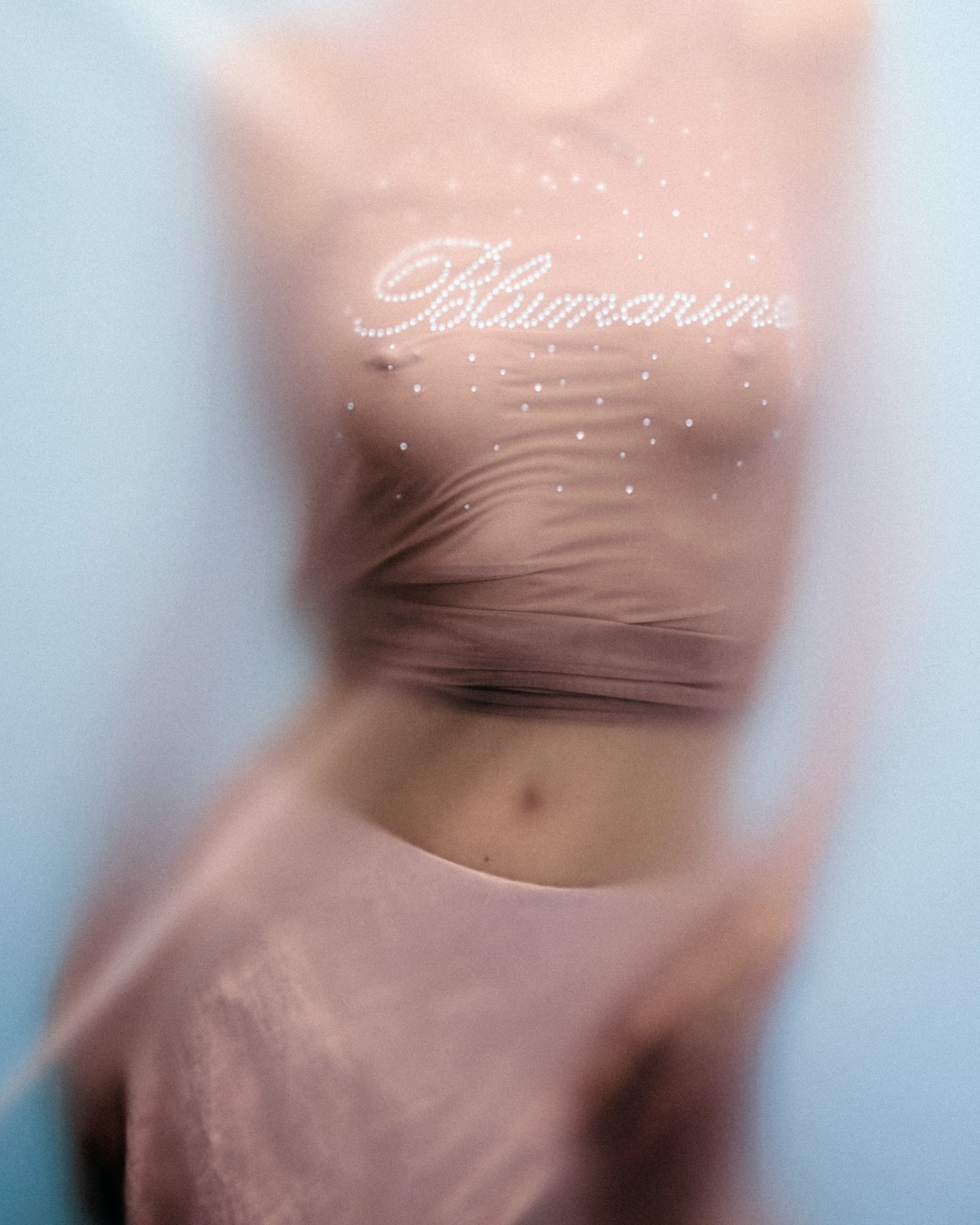 Blurred photo of woman wearing pink top with the text Blumarine.