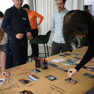 Galerie, die verschiedene Gruppen beim Spielen des Klimapuzzles an Tischen zeigt.
