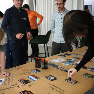 Galerie, die verschiedene Gruppen beim Spielen des Klimapuzzles an Tischen zeigt.