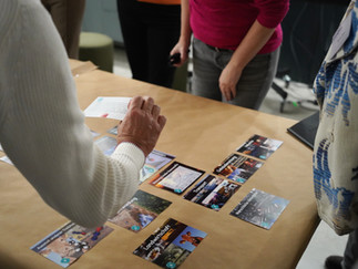 Galerie, die verschiedene Gruppen beim Spielen des Klimapuzzles an Tischen zeigt.