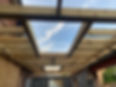 Partially constructed flat roof with two skylight holes during a custom home extension in Pembury