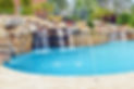large-custom-freeform-pool-with-slide-grotto-waterfall-and-travertine-aqua-design-pools-an