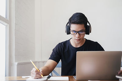 Jovem universitário de origem asiática, concentrado em frente ao computador