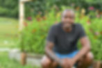 Amaan smiles in front of flowers in the garden