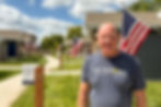 John Holter smiles in front of tiny homes at VCP Village