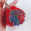 Thumbnail: Blue Red Glitter Resin Holographic Flower on Red Pom Pom Keychain