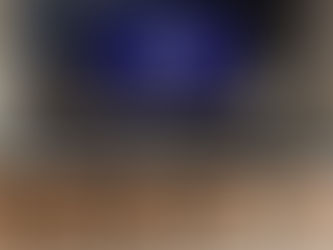 An espresso bar with a white counter top, brown chairs, and a blue honeycomb backsplash