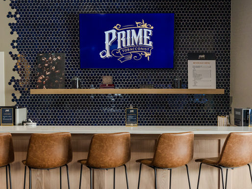 An espresso bar with a white counter top, brown chairs, and a blue honeycomb backsplash