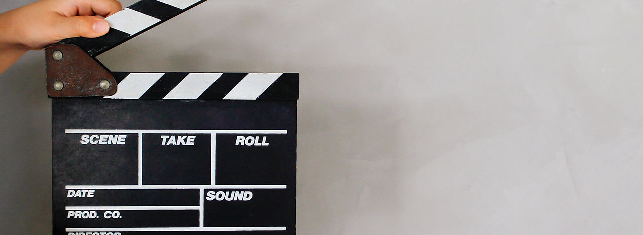 Kid's hand holding film clapper board wi