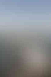 Documentary style wedding photography of a bride and groom playing in the ocean.