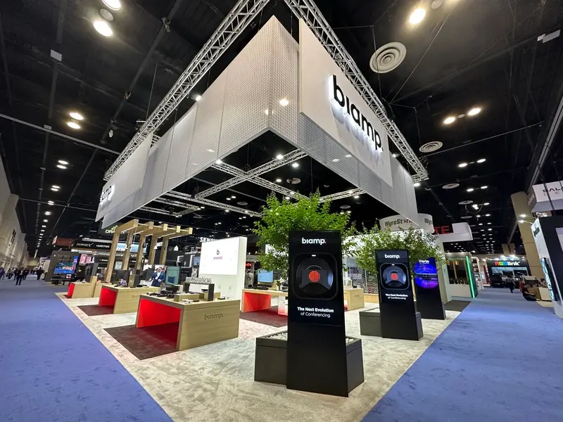 Large Biamp trade show booth at InfoComm 2023 showcasing interactive displays and integrated AV technology demonstrations
