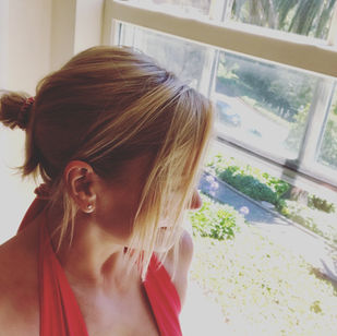 LaReine looking out the window wearing a red top