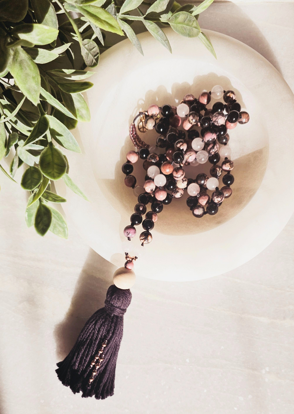 Overhead view of the Vibrations of Love and Protection mala Displayed in a white marble dish