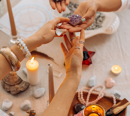A lady with bracelets and rings receiving a piece of raw amethyst from another lady