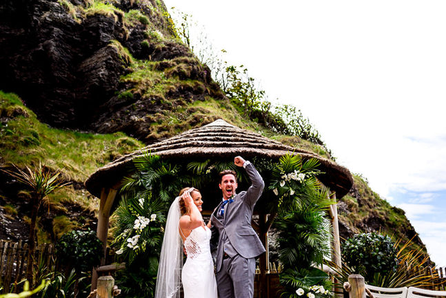 couple just married at Tunnels beaches with foliage arch