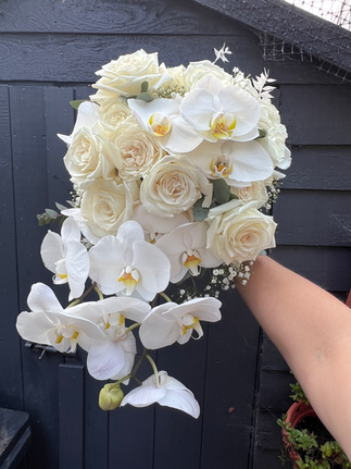 bouquet of white orchids, playa blanca roses and gypsophila in a trailing bouquet 