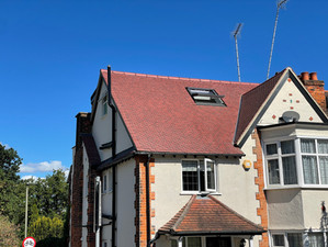 A large period home with a red-tiled dormer loft conversion and a pitched roof.