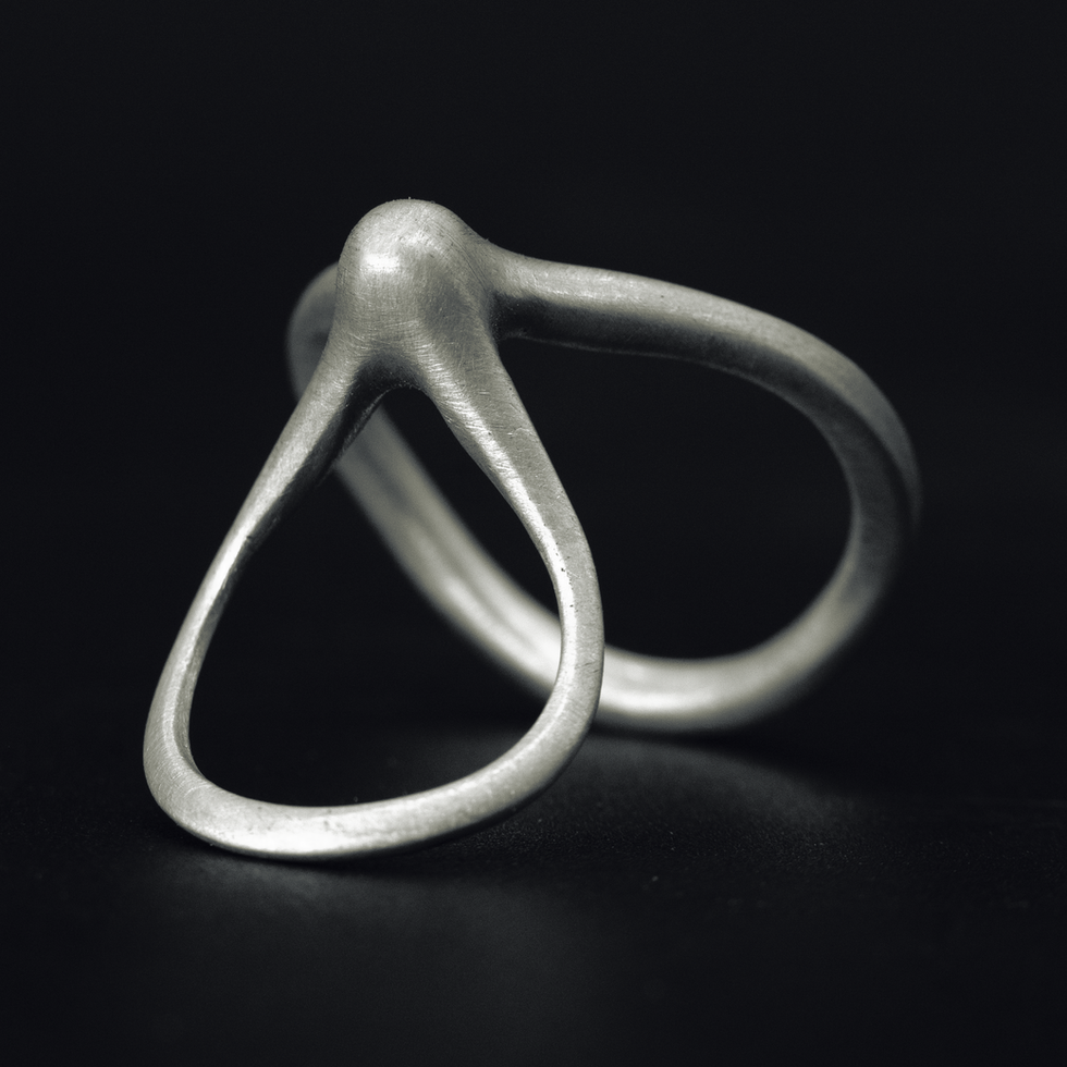 Sculptural silver ring with two flowing loops – angled close-up
