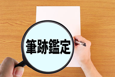 拡大鏡で手書き文字を鑑定している様子