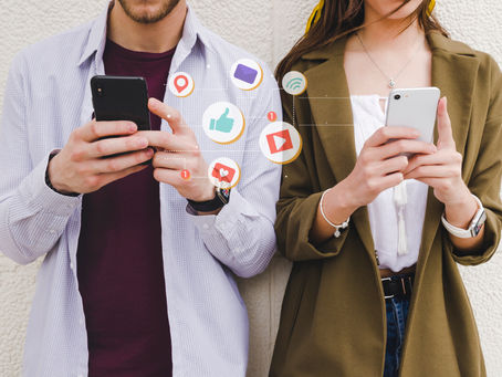 Deux personnes sur leurs téléphones en train de scroller sur les réseaux sociaux