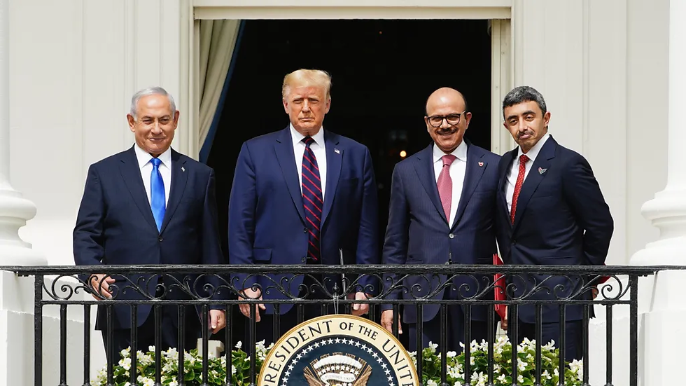 Four men in suits stand on a balcony, smiling. Behind them, an open balcony door. A seal reads "President of the United States."